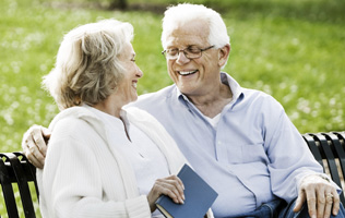 older couple sitting on a park bench